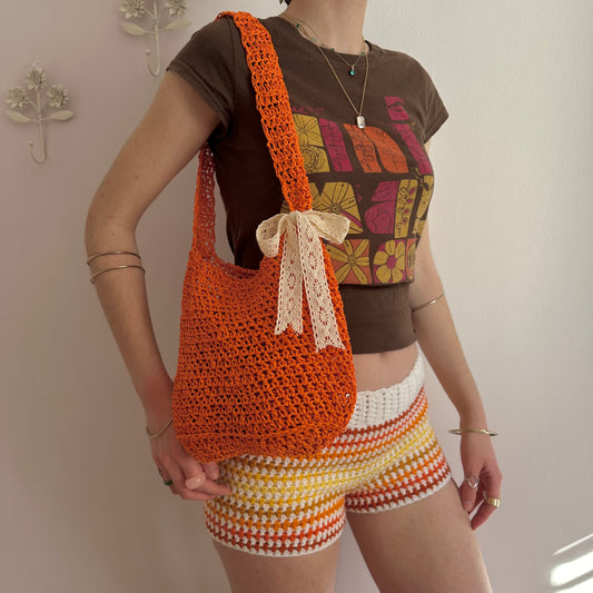 Handmade orange crochet straw bag with cream lace bow