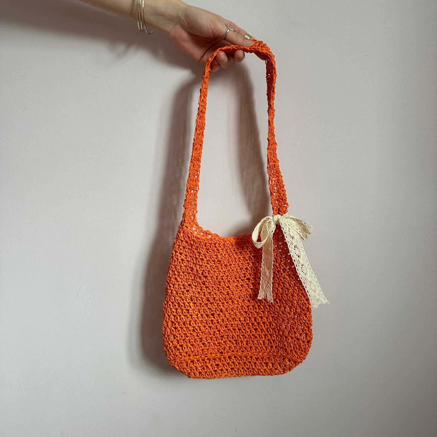 Handmade orange crochet straw bag with cream lace bow