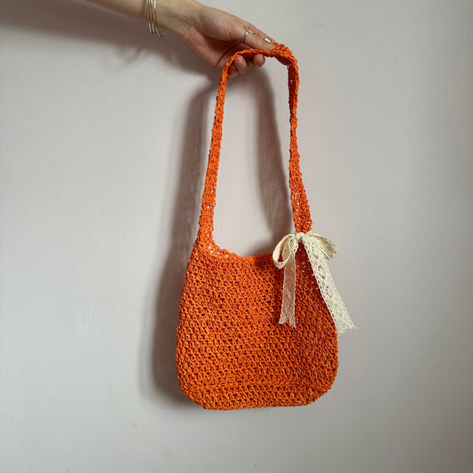 Handmade orange crochet straw bag with cream lace bow