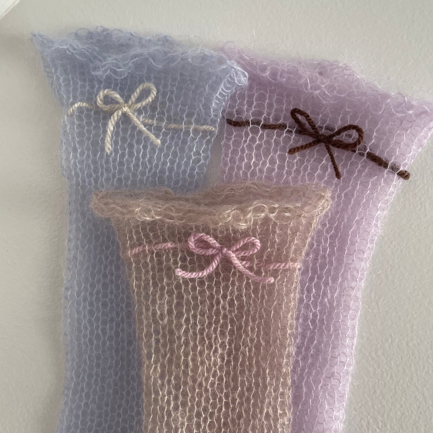 Handmade knitted mohair hand warmers in lilac with brown bow