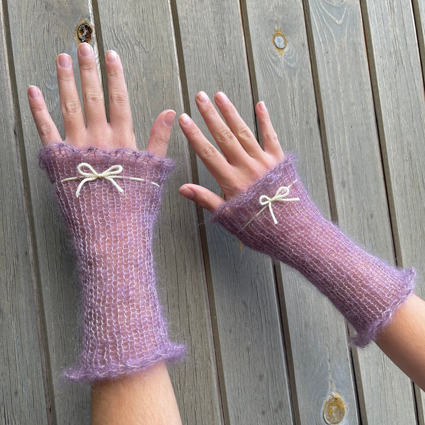 Handmade knitted mohair hand warmers in dusky purple with pastel yellow bow